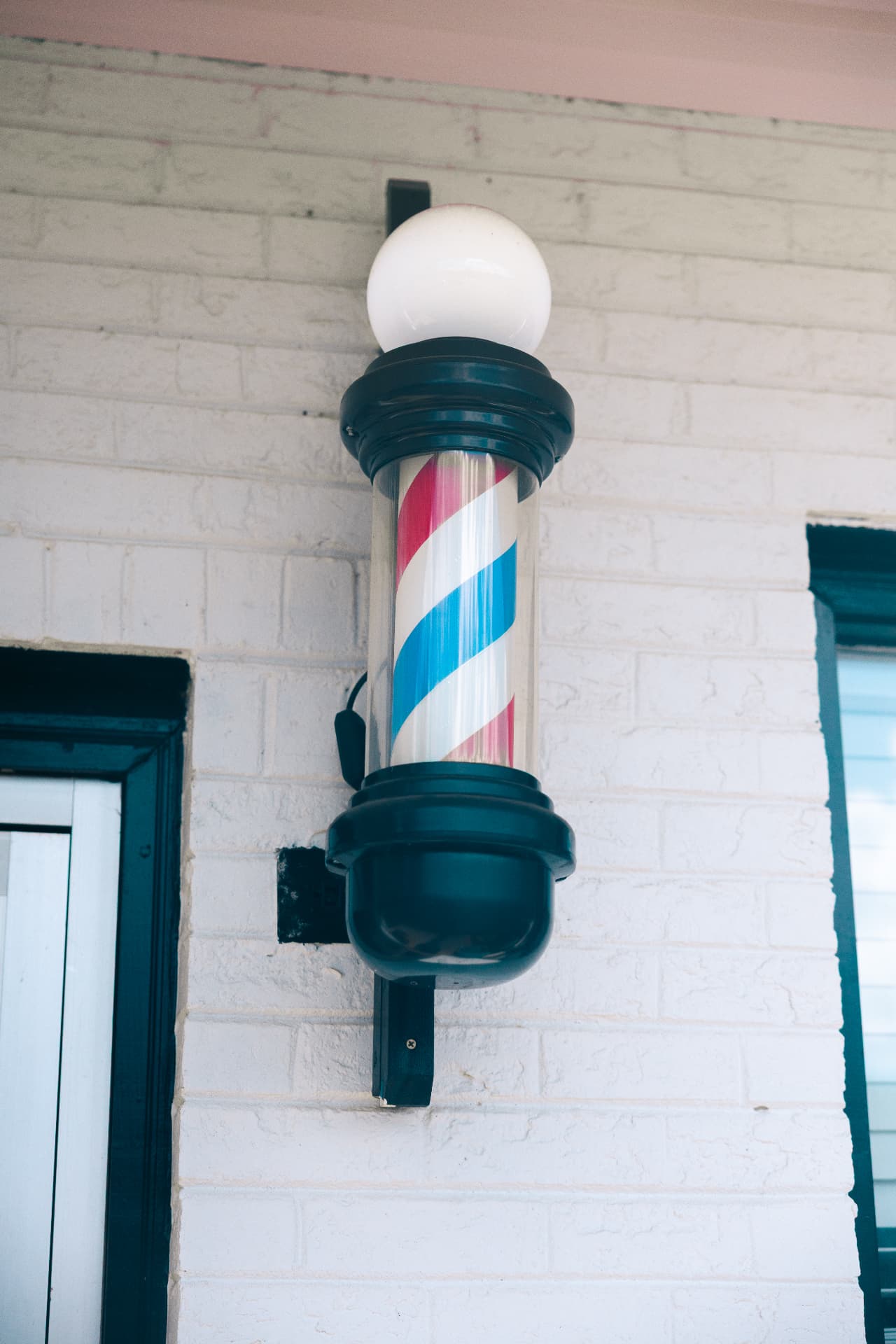 Classic red, white and blue barber pole outside Verified Cuts 2 in Fort Mill, SC.